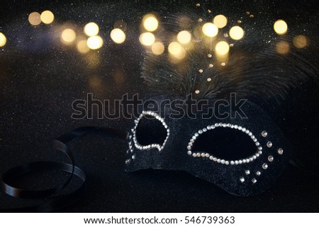 Image of black elegant venetian mask on glitter background. Shiny overlay