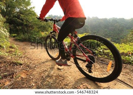 riding mountain bike at sunrise forest trail