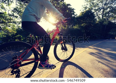 one young woman riding bike on forest trail