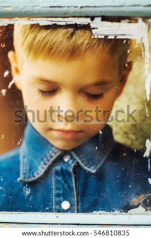 Child's happy face . Portrait of a Cute Kid.  little boy with short blond hair and brown yeas. Beautiful little boy seven years posing with a hat and denim shirt. Smailing boy