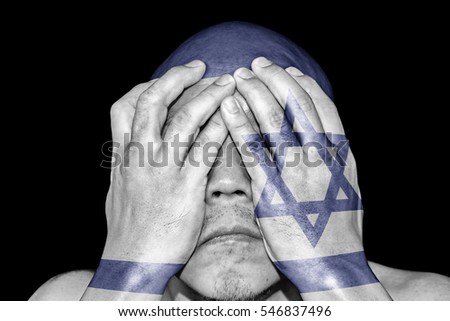 A man covering his eye with his hand with imprint of the Israeli flag for the concept: Justice is blind in Israel.
