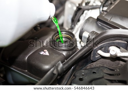Pouring antifreeze to the car  Royalty-Free Stock Photo #546846643