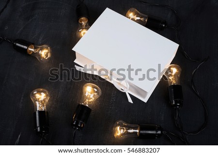 Gift Box and light bulbs to the dark background