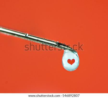 Love injection concept with a syringe an a heart refracting in a drop