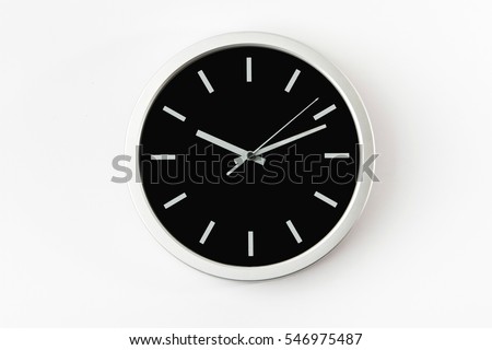 Black clock hanging at the wall Royalty-Free Stock Photo #546975487