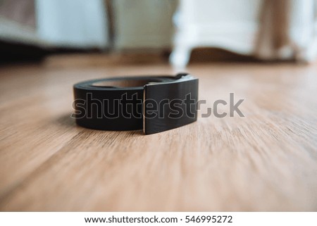 Black leather belt on the floor of the groom. Business style black leather belt. Black men belt rolled up in a ball.