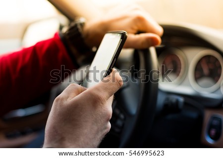 Dangerous texting and driving at the same time Royalty-Free Stock Photo #546995623