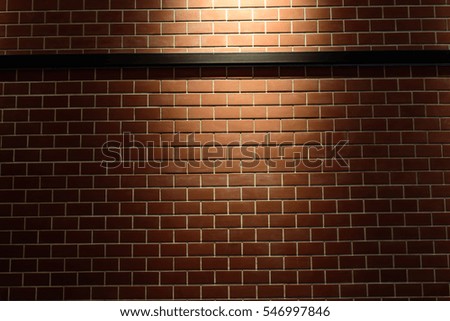 new brown brick wall background texture with a spotlight shining on it.