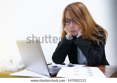 Businesswoman sitting staring notebook on the desk And graph financial 

