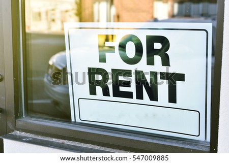 for rent sign for business in window with sunny reflection