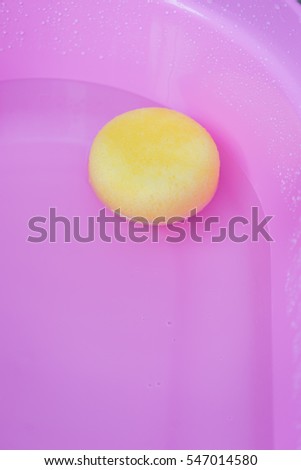 Yellow sponge in pink basin bath prepare for take a shower baby