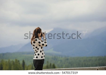 Woman photographer takes pictures in mountain in the summer