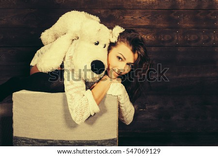 Cute little girl hugging a cute toy. Christmas background