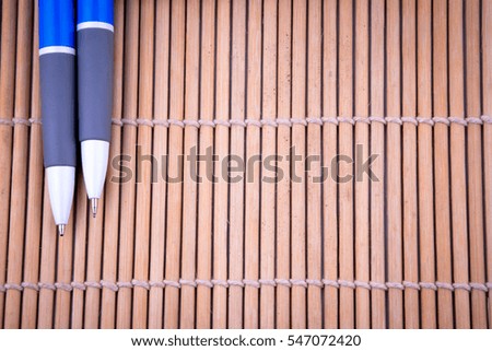 Two pens and white tag on brown color background