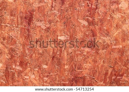 Orange coated recycled oriented strand board close up.