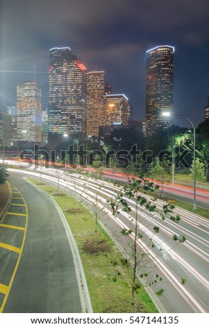 Downtown Houston illuminated at night with traffic lights and modern skylines. The most populous city in Texas and the fourth-most in United States. Architecture, travel and transportation background.