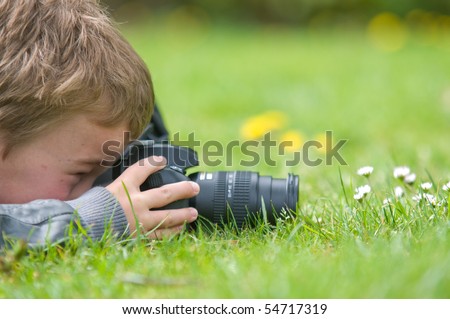 Young boy, nine years old, already practicing with an SLR shooting pictures of nature.
