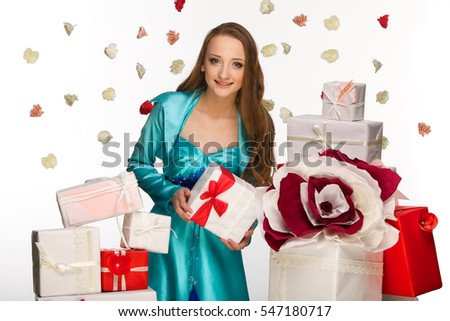 Young beautiful girl with boxes of gifts. Portrait of beautiful girl with shiny smile and white teeth isolated on white background. 