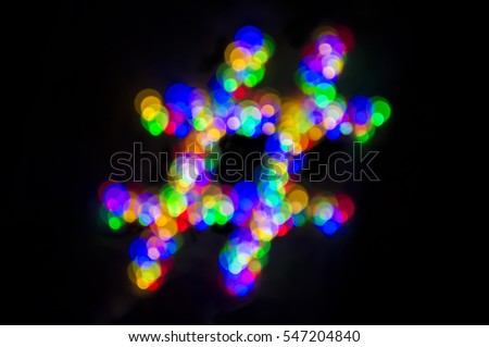 Colorful defocus hashtag of bokeh light bubbles on a black background