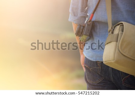 photographer holding camera in  warm sunlight for travel