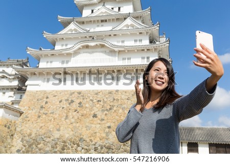 Woman taking selfie by mobile phone in himeji castle