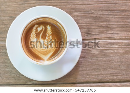 Close up white cup of Coffee, latte with beautiful latte art on the wooden table.