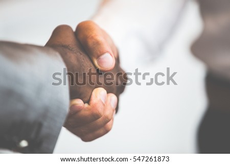 Handshake between african and a caucasian man Royalty-Free Stock Photo #547261873