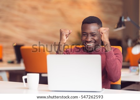 Happy successful African American businessman in a modern startup office indoors Royalty-Free Stock Photo #547262593
