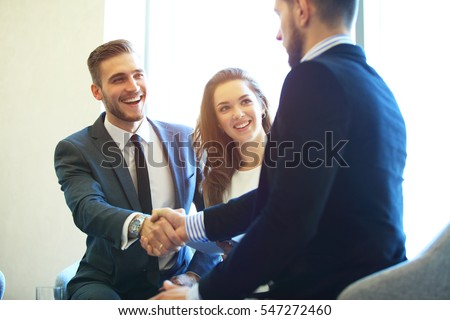 Business people shaking hands, finishing up a meeting Royalty-Free Stock Photo #547272460