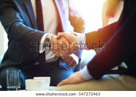 Business people shaking hands, finishing up a meeting Royalty-Free Stock Photo #547272463