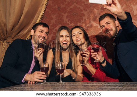 two couples at the party take a selfie with glasses
