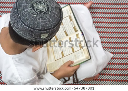 Boy reading al Quran during fasting month (Ramadhan ). 