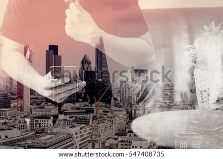 double exposure of designer man hand using smart phone for mobile payments online shopping,omni channel,sitting on sofa in living room,vase rattan with plant on table,London architecture city