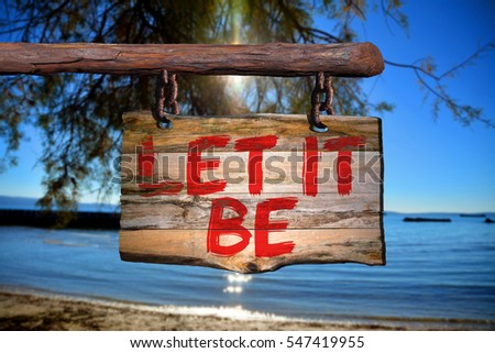 Let it be motivational phrase sign on old wood with blurred background