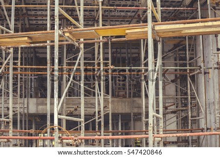 Scaffolding background, elements construction with platforms for work at construction site. Abstract under construction. Vintage style.
