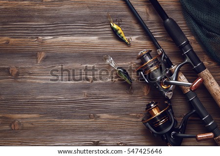 Fishing tackle - fishing spinning, hooks and lures on darken wooden background.Top view. Royalty-Free Stock Photo #547425646