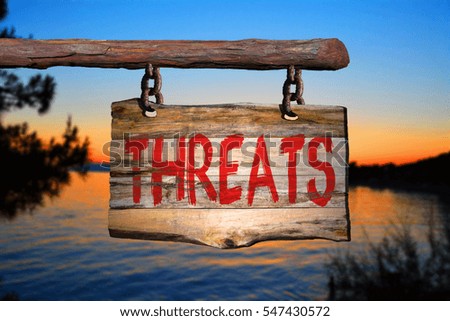 Threats motivational phrase sign on old wood with blurred background