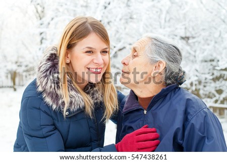 Picture of a happy young woman talking a walk with her grandmother