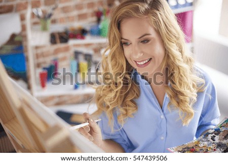 Woman is smiling while creating image  