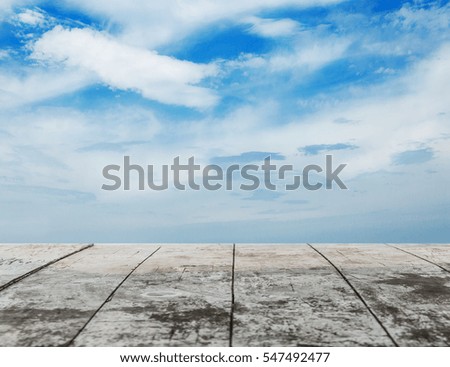 Empty top of old wooden floor texture/background view in front of blue sky background, meaning display, montage or mock up for your product.