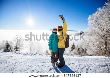 Skiers taking picture over a mountain