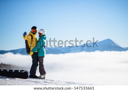 Skiers taking picture of themselves with smart phone over a mountain