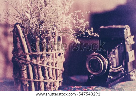 Vintage still life with old camera and wooden vase. aged photo