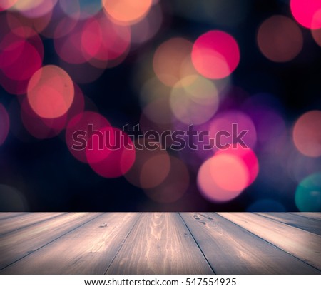 Wooden floor in front of abstract bokeh color background