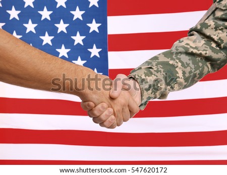Soldier and civilian shaking hands with USA flag on background. Civilians protection concept