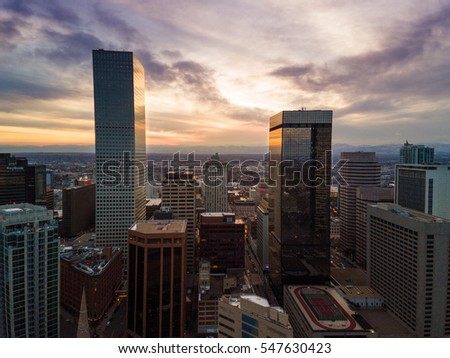 Aerial/drone photo of the capital city of Denver Colorado at sunset.  Rocky Mountains can be seen on the horizon