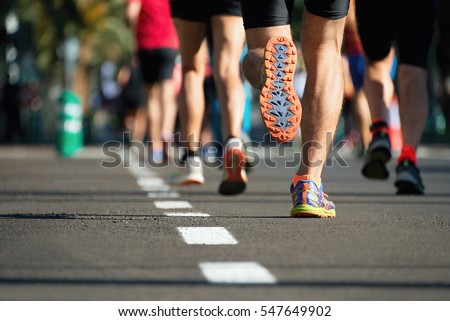 Marathon running race, people feet on city road Royalty-Free Stock Photo #547649902