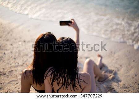 Two friend are taking selfie on the beach