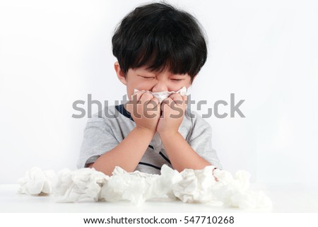 Sick little Asian boy wiping or cleaning nose with tissue isolated white background Royalty-Free Stock Photo #547710268