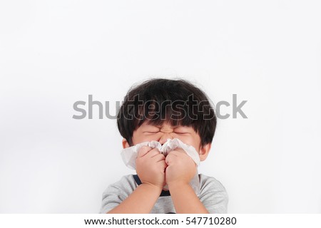 Portrait of a little Asian boy wiping and cleaning nose with tissue isolated white background. Royalty-Free Stock Photo #547710280